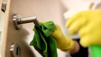 Close-up of unrecognizable person cleaning door handle.