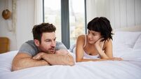 Young couple talking on their bed in the morning