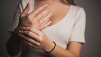 Close-up woman massaging her arthritic hand and wrist, she is suffering from pain and rheumatism