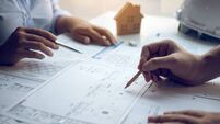 Engineering man showing blueprint detail for people buying house.
