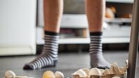 Broken eggs - accident at kitchen, mess. Legs on background