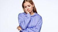 Unhappy teenage girl with head in hand