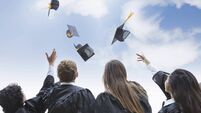 Excited group of college graduates throwing their hats in celebration