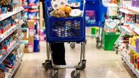 Full shopping cart, customer is stocking vital needs because of global chaos. Shopping with blur supermarket store products, int