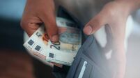 Young man holding in hands wallet with euro money