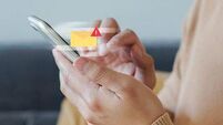 close up employee man hand holding smartphone to checking alert from mailbox with warning sign for email spam security and prote