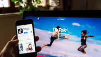 PRAGUE, CZECH REPUBLIC - NOVEMBER 22 2018: TikTok mobile video-sharing app company logo on phone screen with internet homepage i