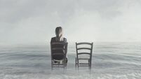 alone woman sitting next to her lover's empty chair