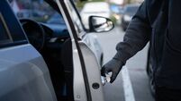 Close-up shot of a thief wearing a black shirt and black gloves. He tried to open the car door and tried to break in. car theft