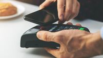 contactless payment - woman paying bill with smartphone at cafe